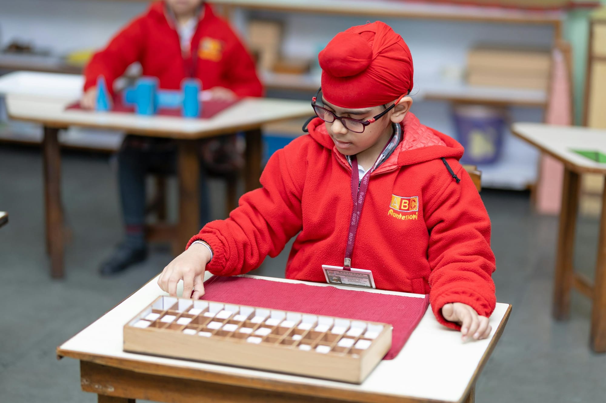 Montessori sınıfında ahşap materyalle çalışan bir çocuk