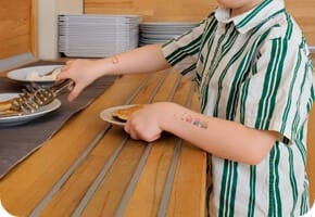 Montessori sınıfında bir çocuk kendi tabağını servis ediyor