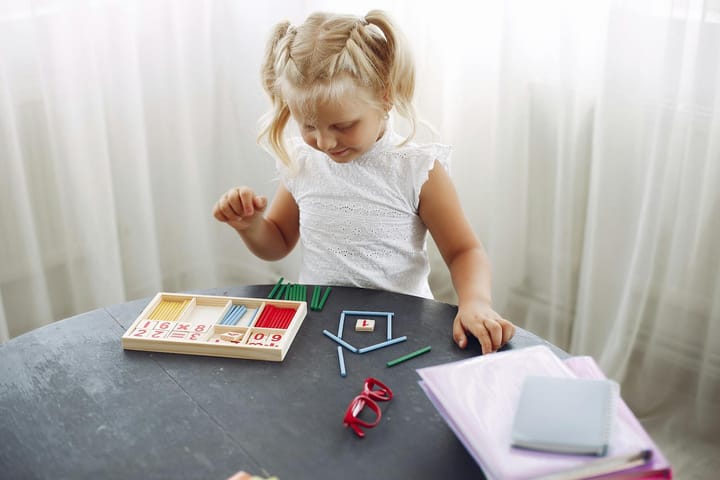2-4 yaş çocuk düzenli bir Montessori hazırlanmış çevrede kendi seçtiği materyale uzanırken