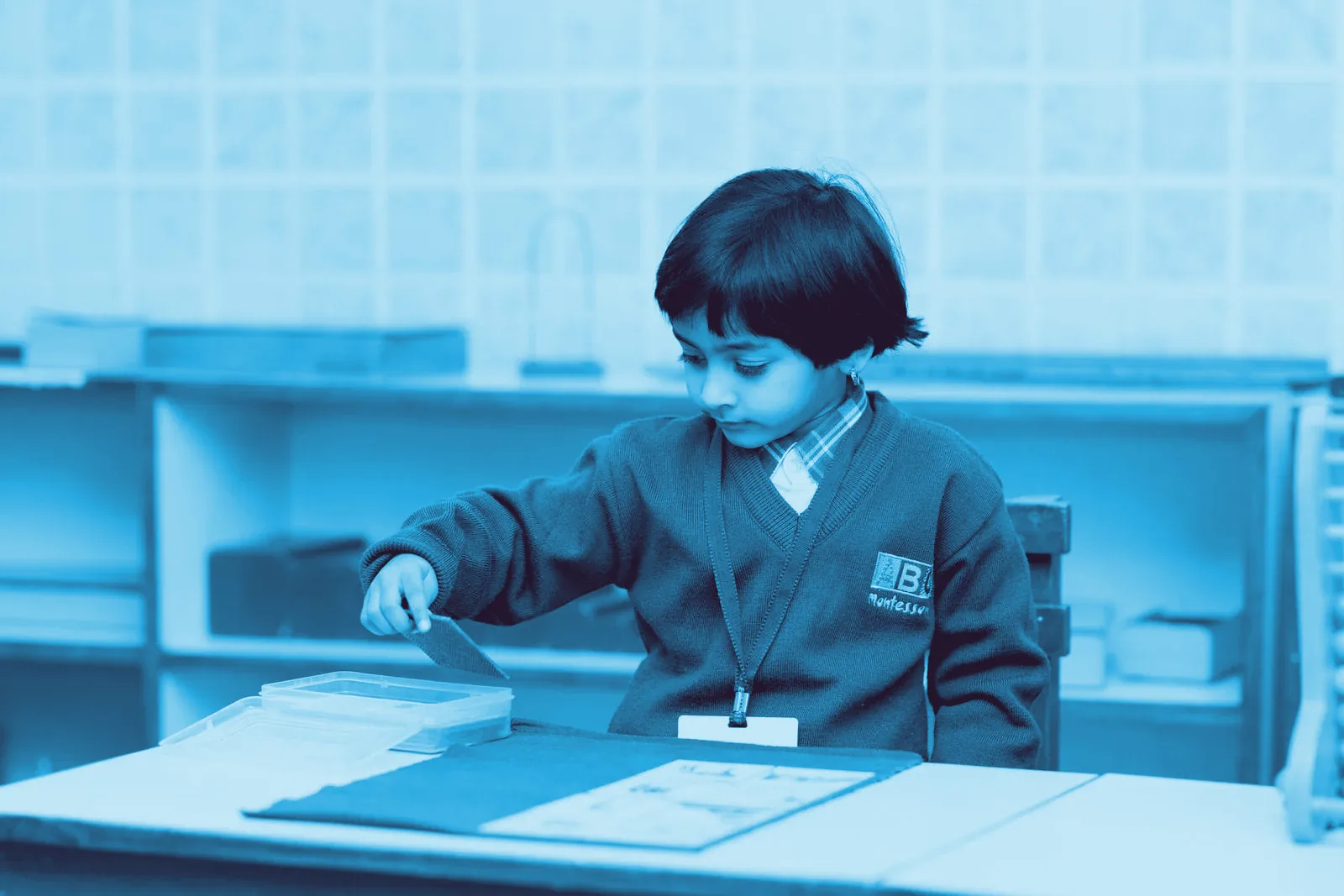 Montessori okulunda materyalle çalışan çocuk